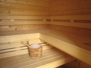 A sauna with wooden benches and a wooden bucket with a handle. - Rural Holiday Home With Outdoor Pool & Sauna (Zuidzande)