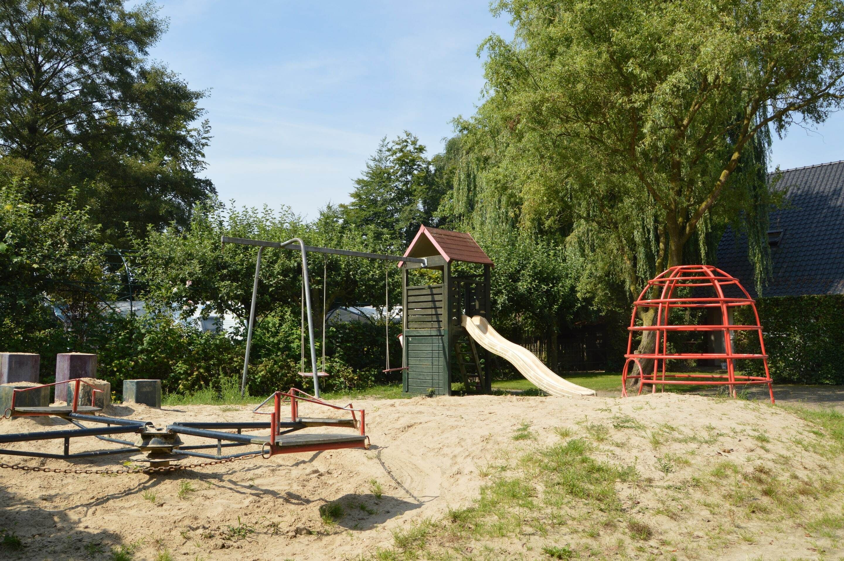 A playground with a slide, swings, and a climbing structure.