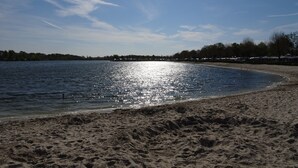 A sandy beach with a calm body of water reflecting sunlight. - Spacious Holiday Home in Eersel With Open Fire (Eersel)
