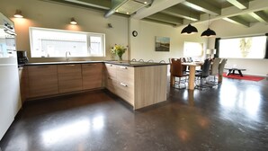 Een moderne keuken met een centraal eiland, houten kastjes en hanglampen.