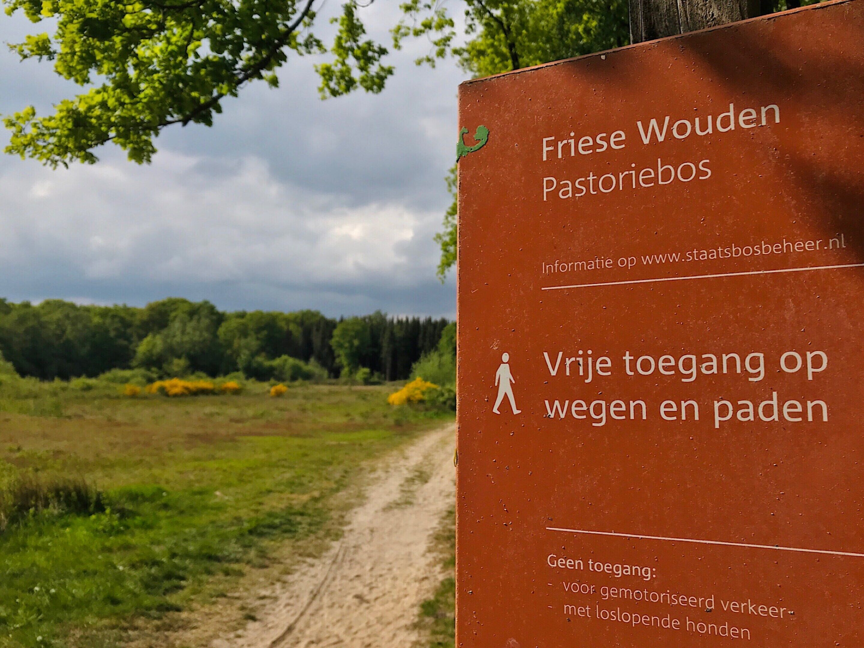 Een bordje voor een wandel- en fietspad in een natuurlijke omgeving.