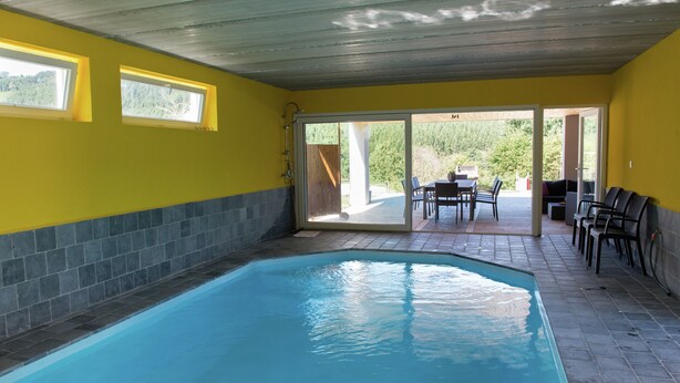 A swimming pool with a tiled deck, a covered patio area with outdoor seating, and a view of the outdoors. - Holiday Home in Stoumont near Town of Spa (Stoumont)