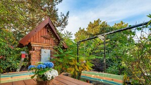 A wooden table with benches, a birdhouse, and a hanging swing.