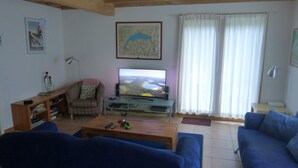 A living room with a television, a sofa, a chair, and a coffee table. - Chalet in Saint-jean Near Ski Lift (Saint-Jean-d'Aulps)