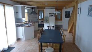 A compact kitchen with a dining area, wooden ceiling, and a small island. - Chalet in Saint-jean Near Ski Lift (Saint-Jean-d'Aulps)