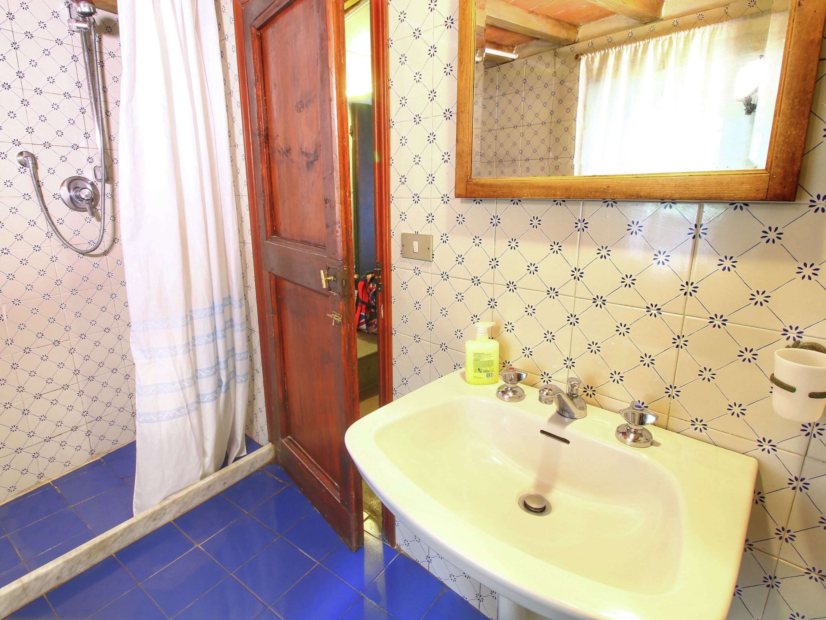 Une salle de bain avec une douche, un lavabo et un miroir.