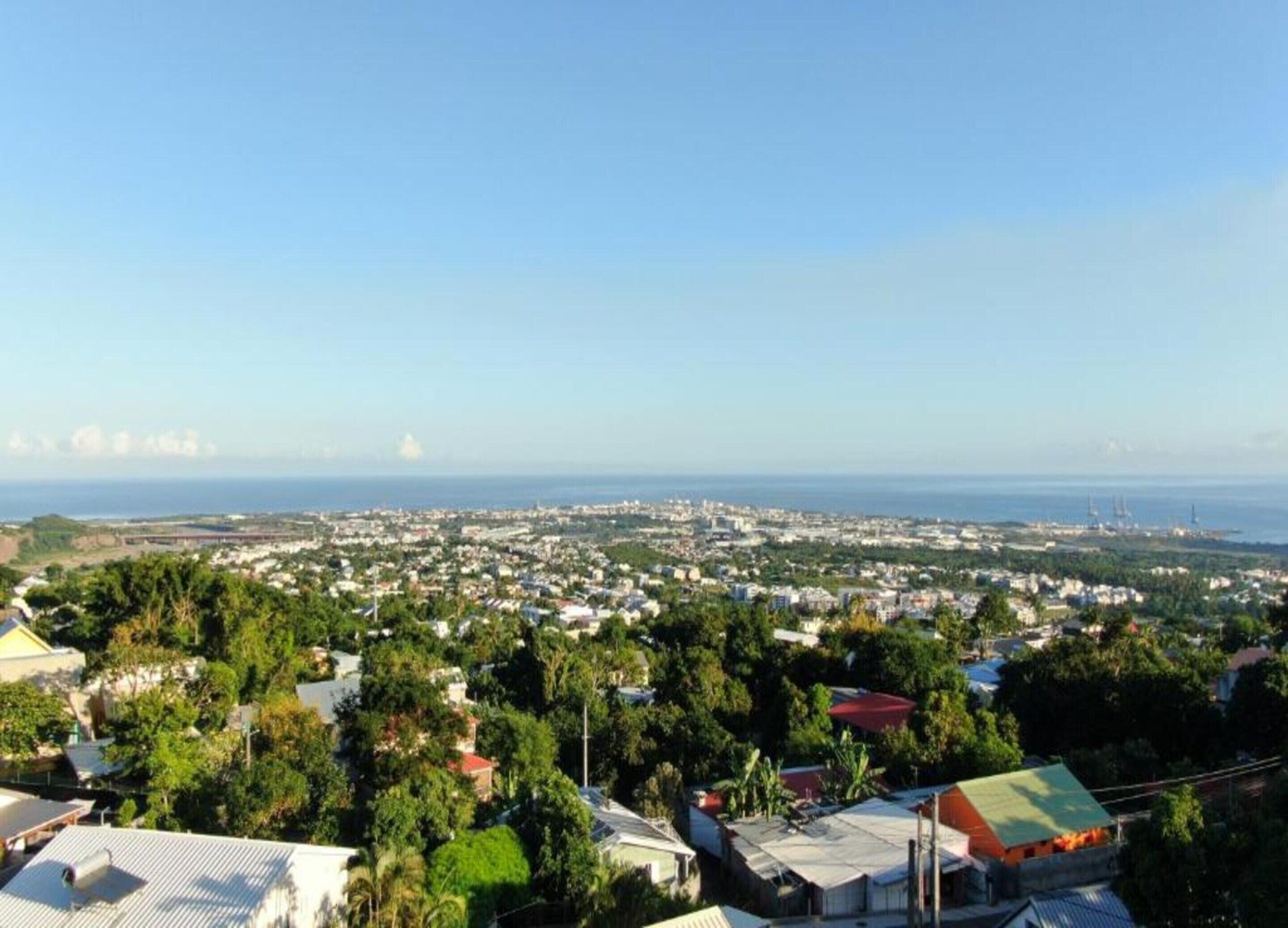 A coastal cityscape with residential buildings and a clear view of the sea.