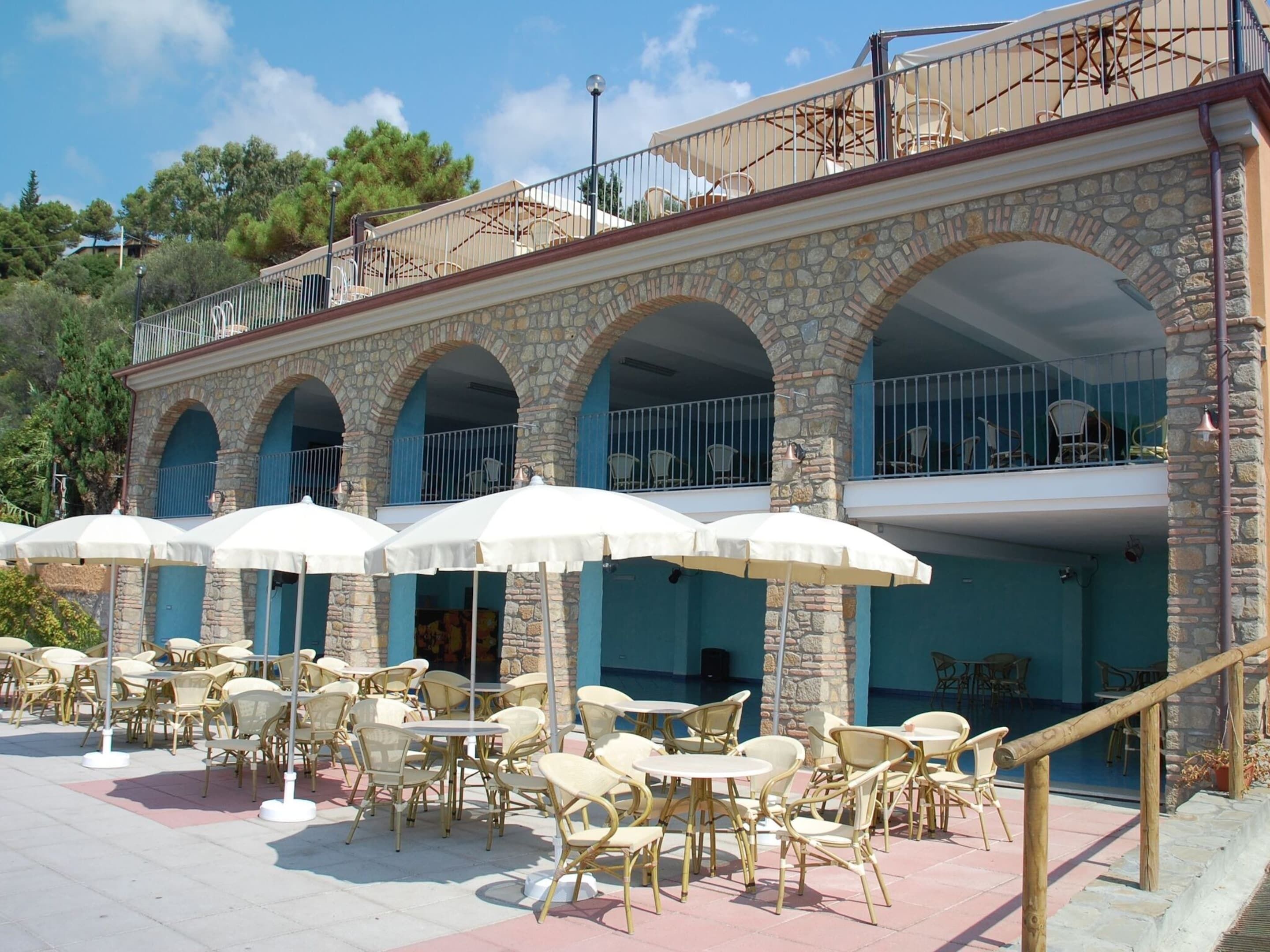 A building with outdoor seating and a pool.