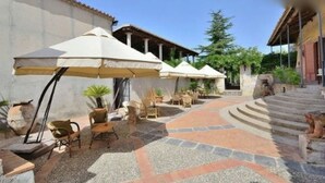 Un patio con asientos al aire libre, sombrillas y un camino de piedra.