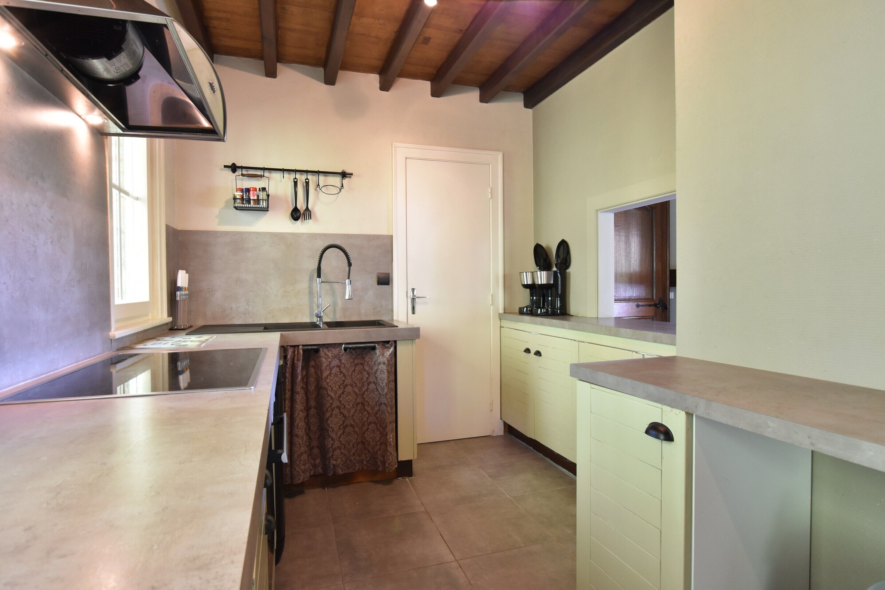 A kitchen with a built-in stove, a sink, and a window.