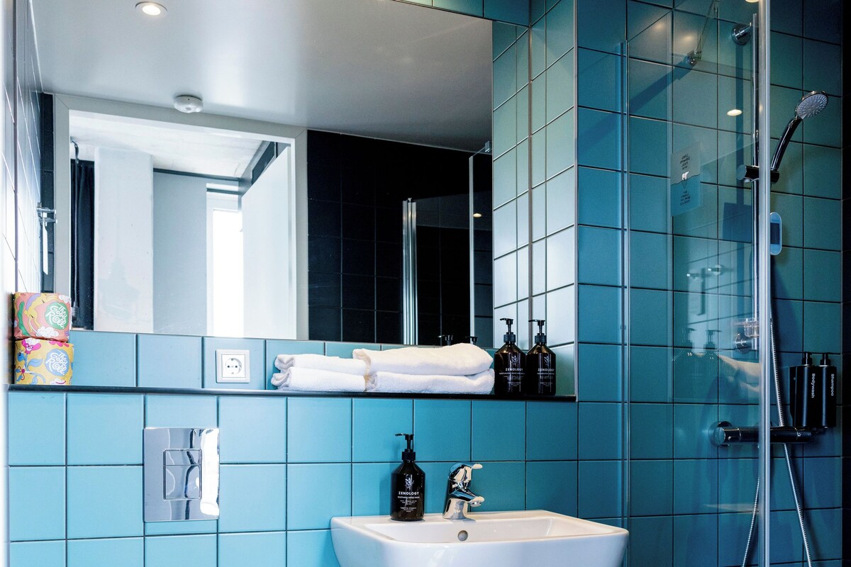 A modern bathroom with a white toilet, a sink, and a shower.
