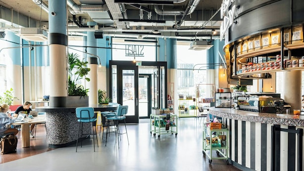 Un intérieur moderne avec un espace bar, des sièges et une porte de sortie bien visible.