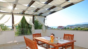 A wooden table with chairs and a view of the sea. - Apartment in Ljubac Near the Sea (Razanac)