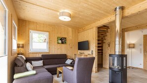 A cozy wooden interior with a sofa, armchair, and a fireplace. - Attractive Chalet With Whirlpool (Sankt Georgen am Kreischberg)