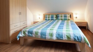 A bedroom with a wooden bed, a wardrobe, and bedside lamps. - Sachsischer Wald Ruckzug (Hohnstein)