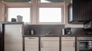 A kitchen with a built-in oven, microwave, and coffee maker.
