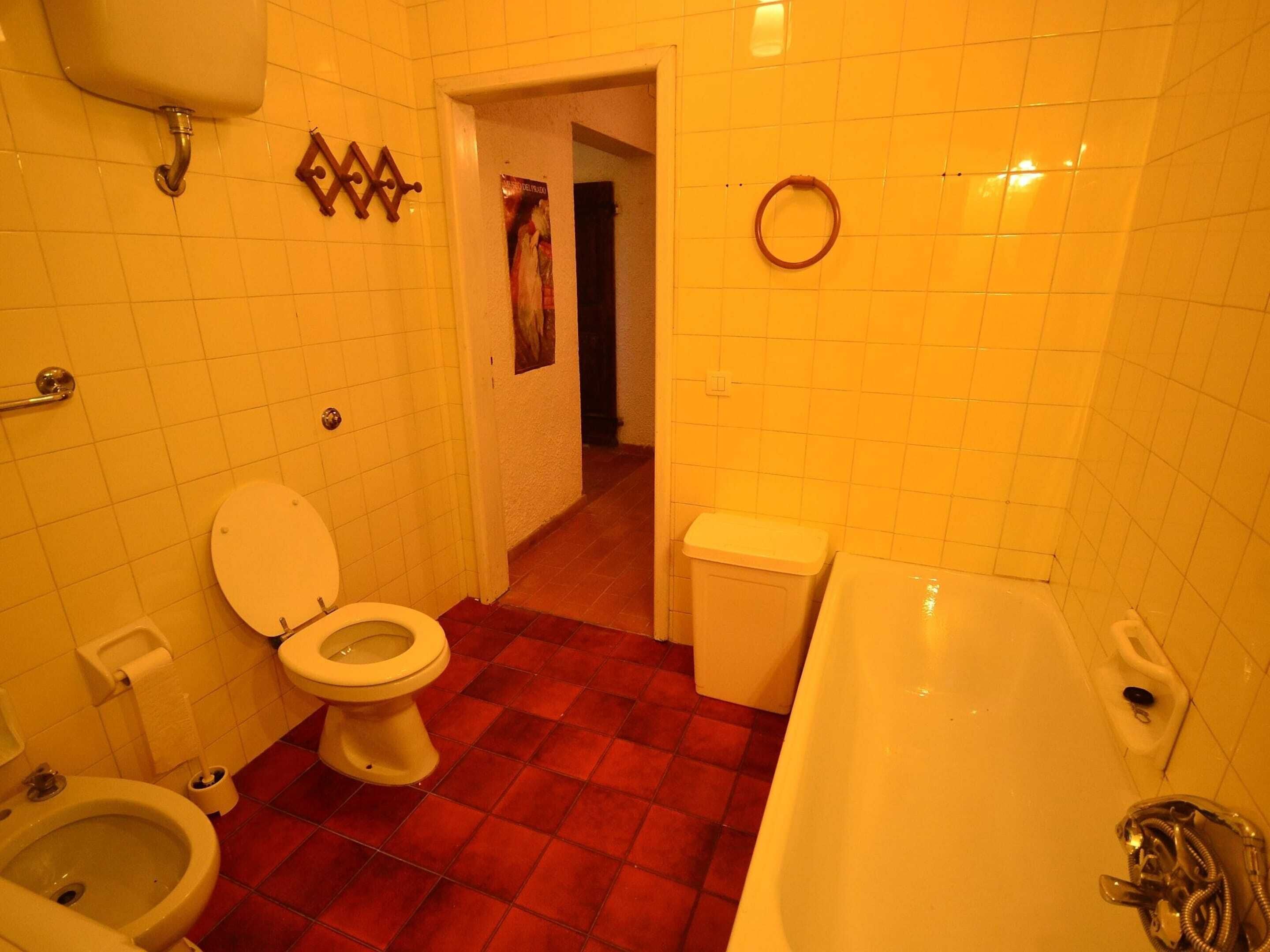 Une salle de bain équipée de toilettes, d’un bidet et d’une baignoire.