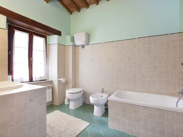 Un baño con inodoro, bidé, lavabo y bañera.