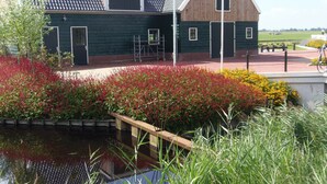 Un bâtiment à l’extérieur d’un vert foncé, doté d’un toit en pente et d’une petite fenêtre de grenier.