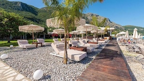 Ein Resort mit Außenbereichen, Palmen und einer Holzterrasse.