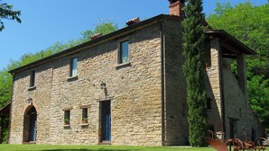 Ein Steinhaus mit flachem Dach, Schornstein und einem kleinen Anbau mit Fenster.