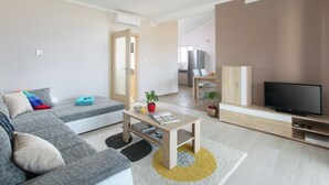 A modern living room with a grey sofa, a wooden coffee table, and a flat-screen TV. - Detached Villa With Private Pool Located on Hill Overlooking Kvarner (Labin)
