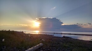 Un atardecer sobre una masa de agua con un muelle de madera que se adentra en el agua.