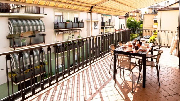 An outdoor patio with a covered seating area, a grill, and a view of neighboring buildings. - Casa Paola 2 - Near the city center (Mestre)
