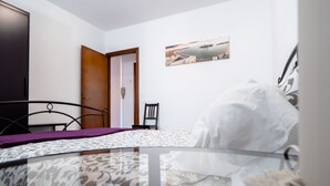 A bedroom with a bed, a chair, a wardrobe, and a door. - Casa Paola 2 - Near the city center (Mestre)