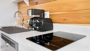 A modern kitchen with a built-in coffee maker, a dishwasher, and a sleek countertop. - 100 Steps to Beach, Deck w Ocean View, Beach Gear (St. Augustine)