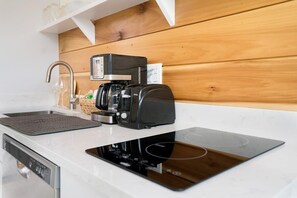 A modern kitchen with a built-in coffee maker, a dishwasher, and a sleek countertop. - 100 Steps to Beach, Deck w Ocean View, Beach Gear (St. Augustine)