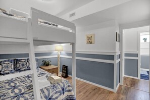 A bunk bed room with a patterned bedspread, a bedside lamp, a framed picture on the wall, and a potted plant. - The Hideaway -Raystown Lake Vacation Rentals, Aunt Susie's (Hesston)