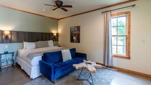 Un dormitorio con cama, sofá azul y una mesa de centro de madera.