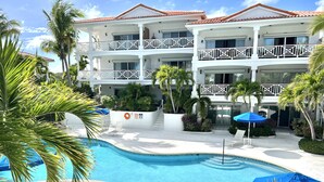 Un resort con piscina, varios balcones y palmeras.