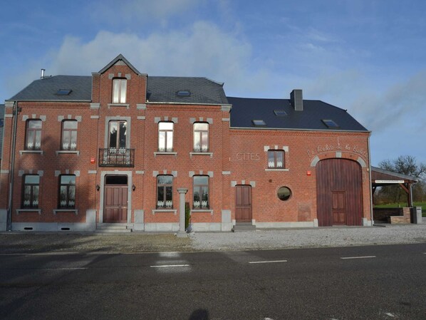 A large brick building with multiple windows and a central entrance.