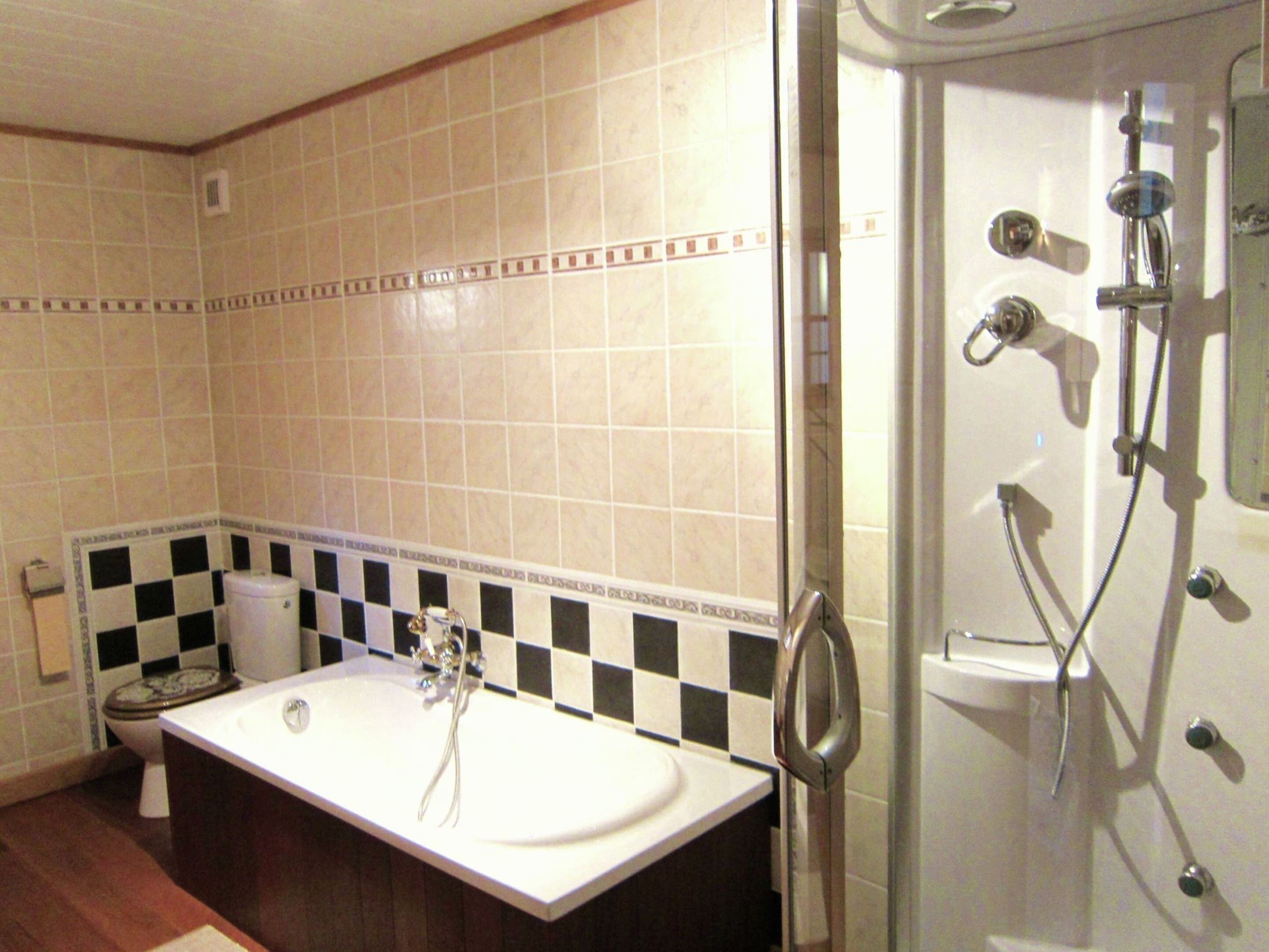 A bathroom with a white sink, a toilet, and a shower area.
