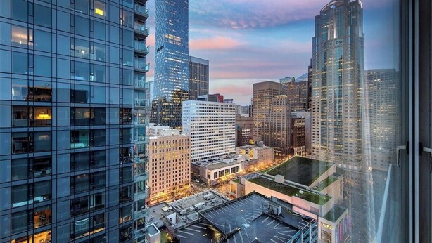 A cityscape with modern high-rise buildings, a parking area, and a view through a window. - Walk to everything: Pike Place Penthouse, Seattle (Seattle)