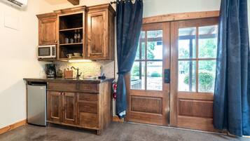 A kitchen with wooden cabinets, a microwave, and a coffee machine.