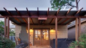 A covered entrance to a building with a sign reading "The Bodega." - The Bodega w/personal hot tub & fireplace (Fredericksburg)