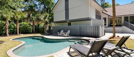 Ein Haus mit Swimmingpool, Außenbereich mit Sitzgelegenheit und einem eingezäunten Deck.