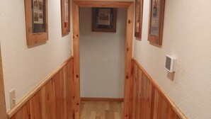A hallway with wooden paneling, a checkered rug, and framed pictures on the walls. - Deep Creek, Lg Yard, Porch Deck, Covered Parking, mile from EVERYTHING (Bryson City)