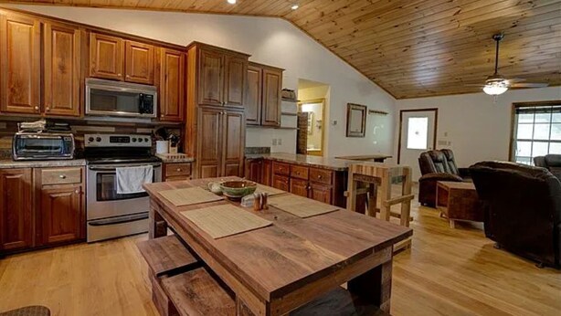 A spacious kitchen with wooden cabinets, a large island, and modern appliances. - Deep Creek, Lg Yard, Porch Deck, Covered Parking, mile from EVERYTHING (Bryson City)