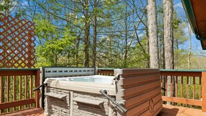Un bain à remous sur une terrasse en bois, avec vue sur les arbres.