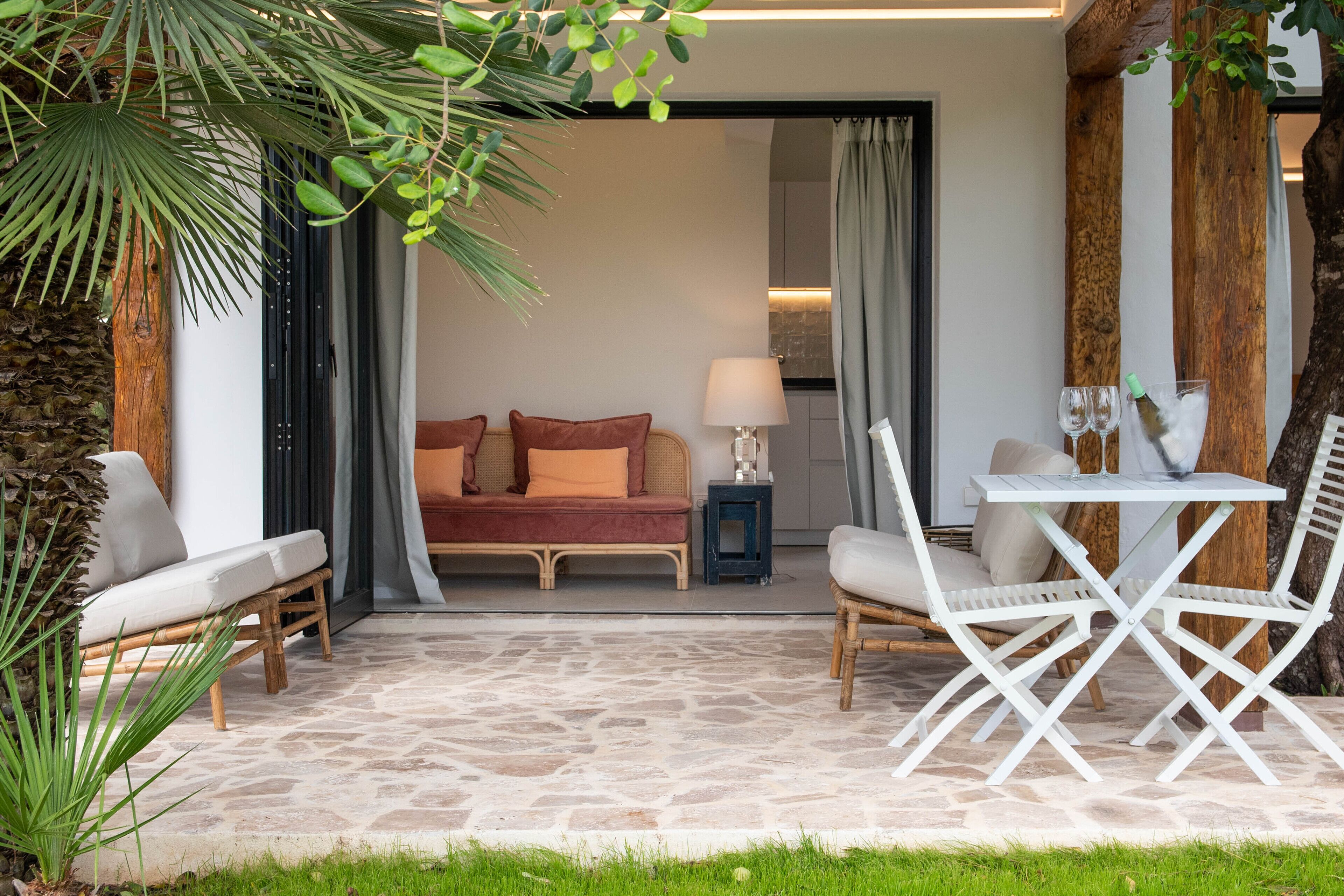 A cozy outdoor seating area with a sofa, two chairs, and a table.