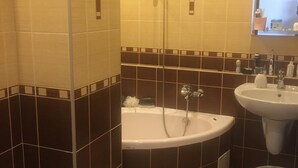 Un baño con bañera, dos lavamanos, inodoro y ducha.