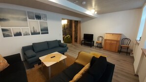 A living room with a sofa, a coffee table, a TV, and a cabinet. - Vacation apartment "Pfalz" - centrally located in Grünstadt (Grünstadt)