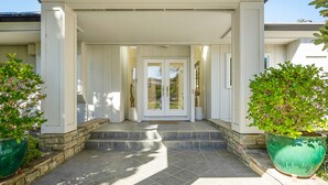 A house with a covered porch, stone steps, and large potted plants. - Beautiful Napa Valley Home on Golf Course -  Perfect Wine Country Retreat (Napa)
