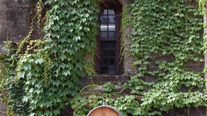 Wooden wine barrels labeled with 'CHATEAU MONTELENA' and vintage years, stacked on a wooden pallet against a stone wall with ivy. - Beautiful Napa Valley Home on Golf Course -  Perfect Wine Country Retreat (Napa)