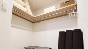 A compact room with a loft bed, a small seating area, and a storage unit. - Hotel ONE'S RESIDENCE (Sapporo)