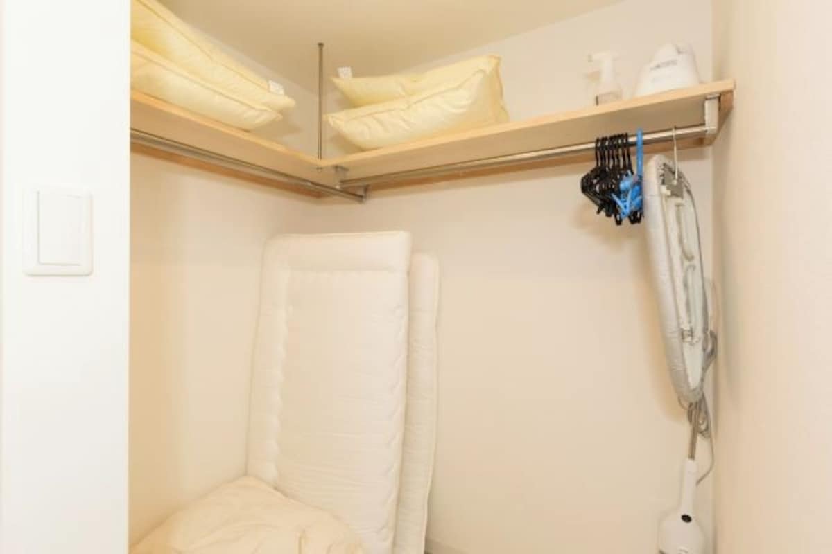 A bathroom with a white bathtub, a towel rack, and a shower head.